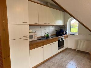 a kitchen with white cabinets and a window at Lieblingsort Buxtehude in Buxtehude