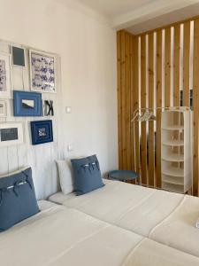 a bedroom with a bed with blue pillows and a shelf at Casa dos Carvalhos in Coimbra