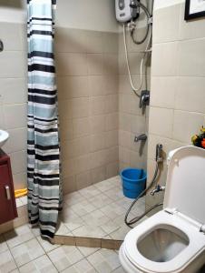 a bathroom with a toilet and a shower with a blue bucket at One Oasis A3 Shortwalk to Sm Mall - Free wifi in Davao City