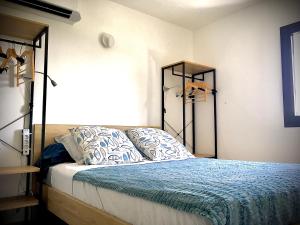 1 dormitorio con 1 cama con edredón azul en Cassis Ma Vie Là en Cassis