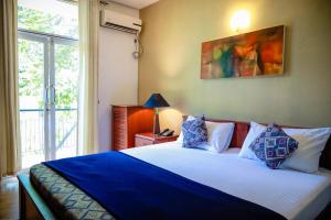 a bedroom with a bed with blue and white pillows at Funk Bunks - Hill Hostel in Kandy