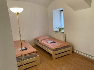 2 Betten in einem kleinen Zimmer mit einer Lampe in der Unterkunft Příjemný apartmán se zahradou in Ostřešany