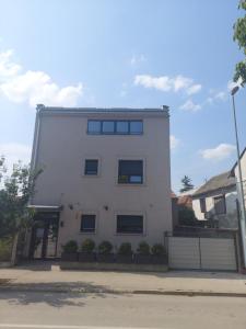 a white building with windows on a street at Nana / Sobe & Apartmani in Valjevo