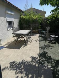 a patio with a table and chairs in a backyard at Petite maison et son jardinet en Village. in Puisserguier