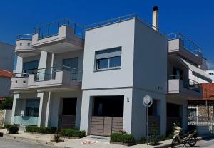 a white house with a scooter parked in front of it at Κομψό studio με δωρεάν πάρκινγκ in Volos
