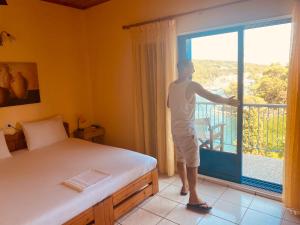 un hombre parado en una habitación con una cama y una ventana en San Giorgio en Gaios