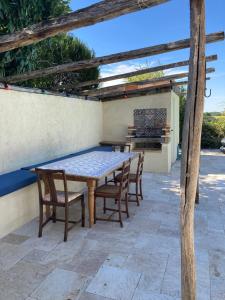 una mesa de madera y sillas en un patio en Rustic cottage with stunning swimming pool en Saint-Front