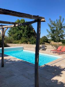 uma piscina com uma pérgula de madeira e uma piscina em Rustic cottage with stunning swimming pool em Saint-Front