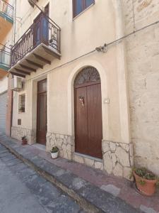 um edifício com uma porta castanha e uma varanda em B&B A San Pasquale em Racalmuto