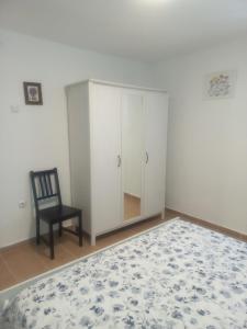 a bedroom with a white cabinet and a chair at Apartment near Olympus mountain in Litochoro