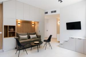 salon z kanapą, stołem i krzesłami w obiekcie Elegant Duplex with XL Patio by FeelHome w Tel Awiwie