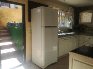 - un réfrigérateur blanc dans une cuisine avec un escalier dans l'établissement Miramar, à Harhoura