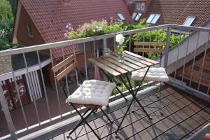 uma mesa de madeira e 2 cadeiras numa varanda em FeWo Elbdeichliebe em Boizenburg