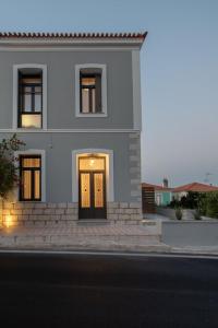 una casa blanca con una puerta en una calle en Villa Samos - Renovated stone villa with private pool- 2 min from the sea! en Samos