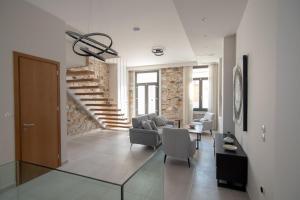 萨摩斯Villa Samos - Renovated stone villa with private pool- 2 min from the sea!的带沙发和椅子的客厅以及楼梯。