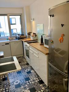 uma cozinha com um frigorífico e um lavatório em Central Montparnasse / Voyage d'affaire / Découverte de la ville em Paris