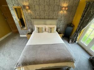 a bedroom with a large bed and a large window at Walnut Tree Cottage Barn in Toppesfield