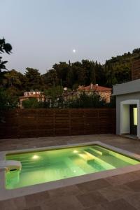a swimming pool with green lighting in a backyard at Villa Samos - Renovated stone villa with private pool- 2 min from the sea! in Samos