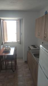 a kitchen with a table and a stove and a window at Almia in Khalíkia