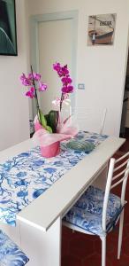 une table blanche avec des fleurs violettes dans un vase sur elle dans l'établissement SUL MARE..., à Misano Adriatico