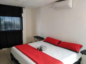 a bedroom with a white bed with red sheets and a window at Black & White casa privada con alberca in Monterrey +39 photos