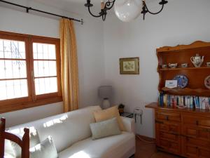 uma sala de estar com um sofá branco e uma janela em 300-Meter-bis-zum-Strand-Caracola-Wohnung-mit-Garten em Chipiona