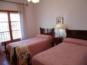 um quarto com 2 camas e uma janela em 300-Meter-bis-zum-Strand-Caracola-Wohnung-mit-Garten em Chipiona
