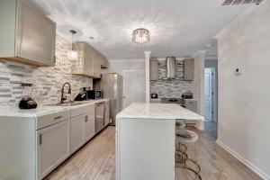 a kitchen with white cabinets and a stone wall at Royalty in the Magic City in Birmingham