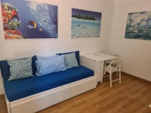 a room with a blue bed and a desk at Sunshine Apartment in Rome