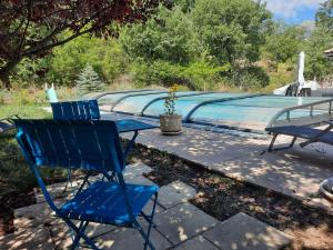 a pair of blue chairs sitting next to a swimming pool at Le boisnheur in Gap