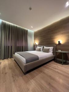 Un dormitorio con una cama grande y una ventana grande. en Tirana Apartments, en Tirana