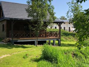 una terraza de madera en un patio junto a una casa en Na Tałandy, en Szczebrzeszyn