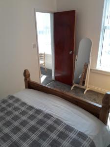 a bedroom with a bed and a mirror and a door at Southbay Holiday Flats Flat 2 in Bridlington