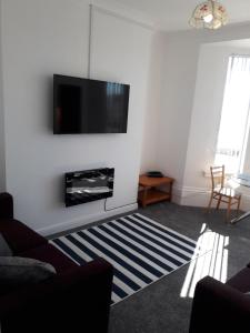 a living room with a flat screen tv on a wall at Southbay Holiday Flats Flat 2 in Bridlington