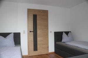 1 dormitorio con 2 camas y puerta corredera en Ferienapartment Horn, en Altendorf