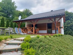 mały domek z altaną i krzesłami w obiekcie Zielony Zakątek Sosnówka w mieście Sosnówka