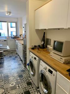 a kitchen with a washing machine and a tv at Central Montparnasse / Voyage d'affaire / Découverte de la ville in Paris
