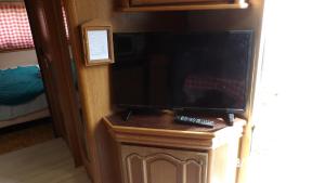 uma televisão de ecrã plano numa bancada num quarto em Calme de la campagne em Le Torp-Mesnil