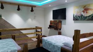 Pokój z dwoma łóżkami i telewizorem na ścianie w obiekcie Hospedagem 3 Estrelas w mieście Navegantes