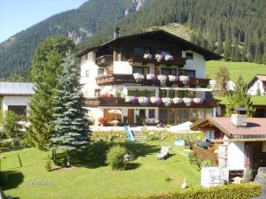 a large building with flowers on the front of it at Gästehaus Bergland in Berwang