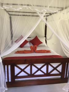 Schlafzimmer mit einem Bett mit Moskitonetz in der Unterkunft Lush Green Villa in Talpe