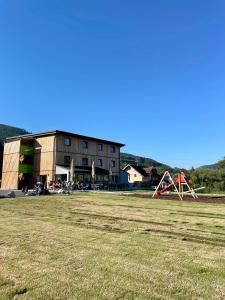 ein großes Feld mit einem Gebäude und einem Spielplatz in der Unterkunft Motel XL Lounge in Traisen