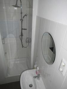 a bathroom with a sink and a mirror and a shower at Haus Abel in Aerzen