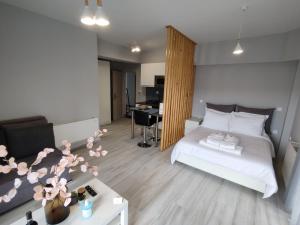 a bedroom with a white bed and a table with flowers at DIFFERENT APARTMENTS in Ioannina