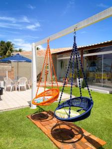 a swing in a yard with a house at Mon Chéri - Pousada Exclusive in Japaratinga