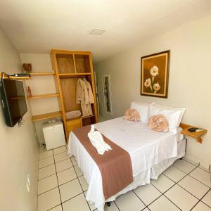 Mon Chéri - Pousada Exclusive في جاباراتينغا: غرفة نوم عليها سرير وفوط