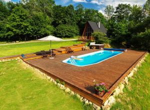 a swimming pool on a wooden deck next to a yard at Dosbajka in Małastów