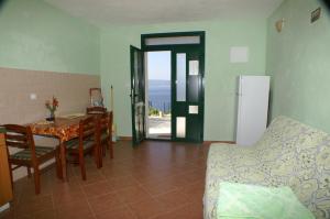 uma cozinha e sala de jantar com mesa e um quarto com vista em Apartments by the sea Marusici, Omis - 2741 em Mimice