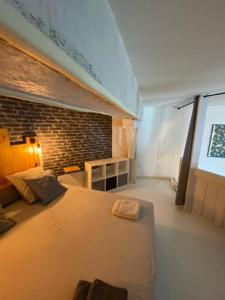 a bedroom with a bed and a brick wall at latypique family in Bourges