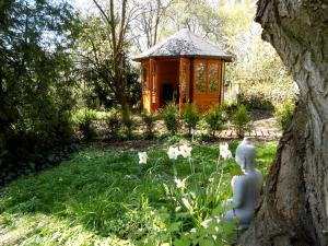 einen hölzernen Pavillon in einem Garten mit Blumen in der Unterkunft Haus Abel in Aerzen